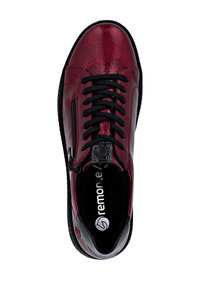 Basket en cuir rouge avec une finition texturée, lacets noirs, zip sur le côté et intérieur rembourré. Conçue pour le confort et le soutien.