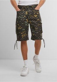 Cargo shorts in a dark camouflage pattern featuring shades of green and brown, with side pockets, adjustable drawstrings, and a relaxed fit.