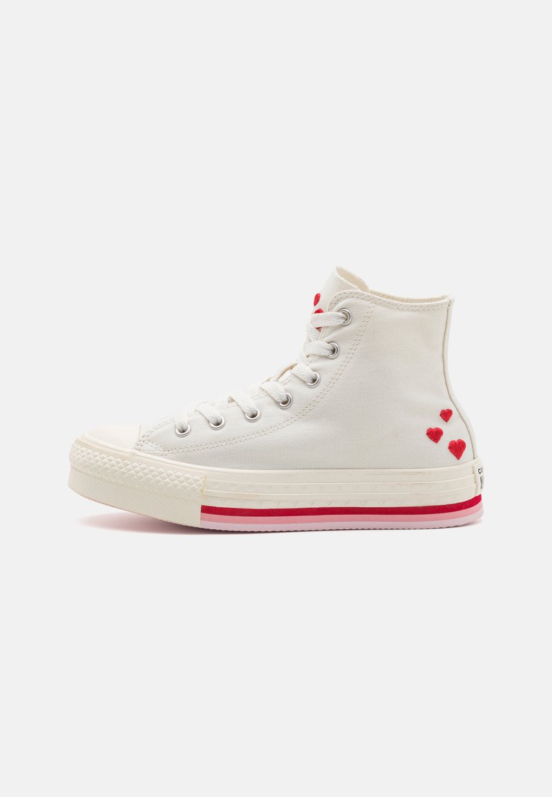 Kangasest kõrgete tossude valge värviga, millel on punane süda tikand, kummist varbakaitse ja kihiline punase ja valge värvi vaheline riba.