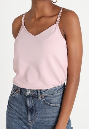 Lyserød camisole-top med v-hals, med blondertrimmede spaghettistropper og en tætsiddende pasform, kombineret med højtaljede denimshorts.