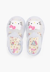 Transparent plastic sandals featuring a Hello Kitty face, pink accent bow, and a patterned insole with colorful graphics.