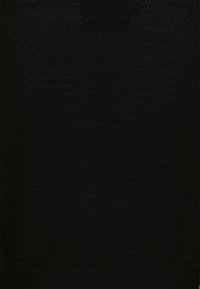 Svart stickad tröja med ett texturerat mönster och ribbad nederkant. Tyget verkar mjukt och något genomskinligt på vissa ställen.