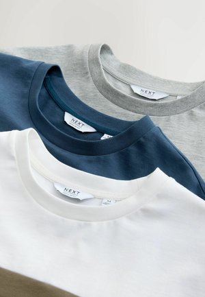 Drei T-Shirts übereinander gestapelt: grau, marineblau und weiß. Jedes verfügt über einen Rundhalsausschnitt und eine weiche Baumwollstruktur, mit Etiketten sichtbar auf der Rückseite.