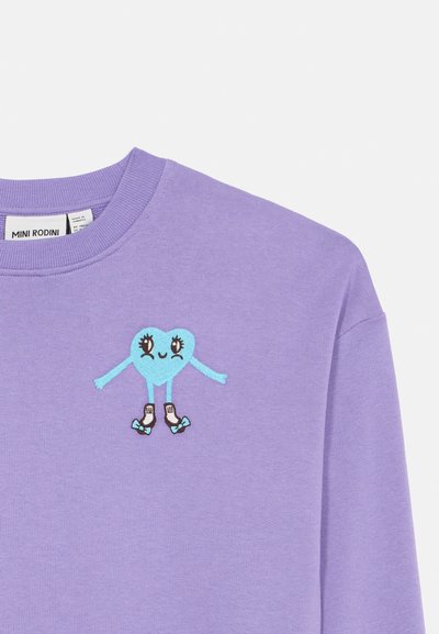Sweatshirt roxo com um coração azul bordado, com olhos e braços, a andar de patins com patins brancos e pretos. Textura suave, design de gola redonda.