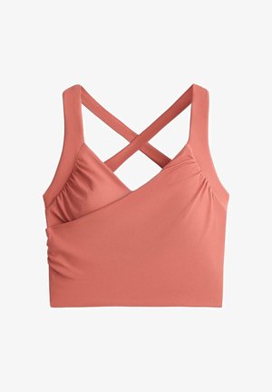 Soft pink cropped tank top with wide crisscross straps and ruched sides on a white background.