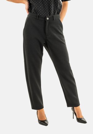Pantalon noir texturé à coupe droite ; doté d'une fermeture à bouton et de poches, associé à des talons hauts noirs.