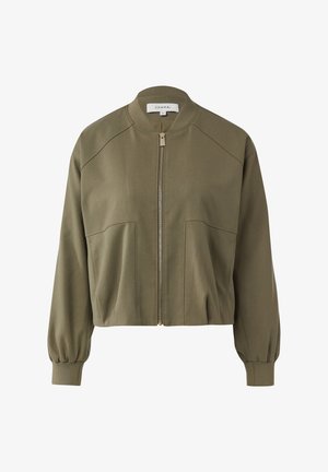 Kurtka bomberka w oliwkowej zieleni z przednim zamkiem błyskawicznym, prążkowanym kołnierzem i puchatymi długimi rękawami. Posiada dwie przednie kieszenie oraz przeszycia jako wykończenie.