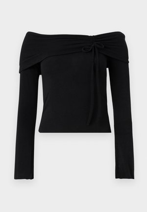 Black off-the-shoulder top with long sleeves, featuring a tie detail at the neckline and a fitted silhouette. Smooth, stretchy fabric.