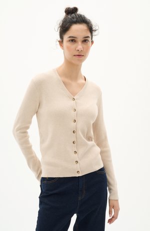 Beige ribbed cardigan with a V-neck, featuring a 7-button closure, long sleeves, and a fitted hem. Worn over dark blue jeans.