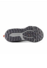 Suela de zapato atlético New Balance en goma gris con relieve triangular y motas naranjas. Presenta una superficie texturizada para mayor agarre y tracción.