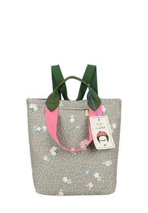 Piccola borsa con manici verdi e rosa, sfondo grigio decorato con piccoli fiori bianchi e rosa, e etichetta Frida Kahlo attaccata.