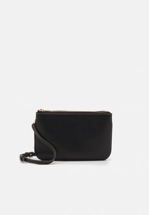 Zwart leren polstasje met gouden rits en afneembare band, minimalistisch ontwerp tegen een witte achtergrond.