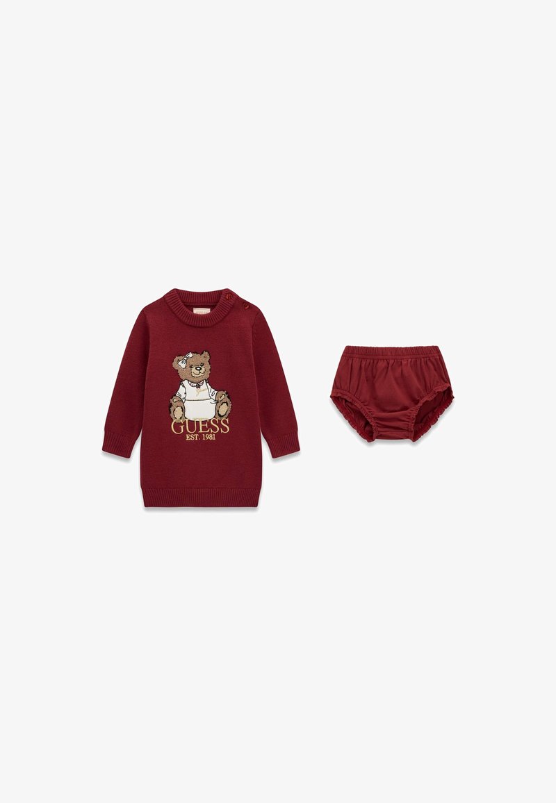 Robe bébé bordeaux avec ours en peluche et logo GUESS, assortie à une culotte de protection bordeaux avec taille élastique et ouvertures pour les jambes.