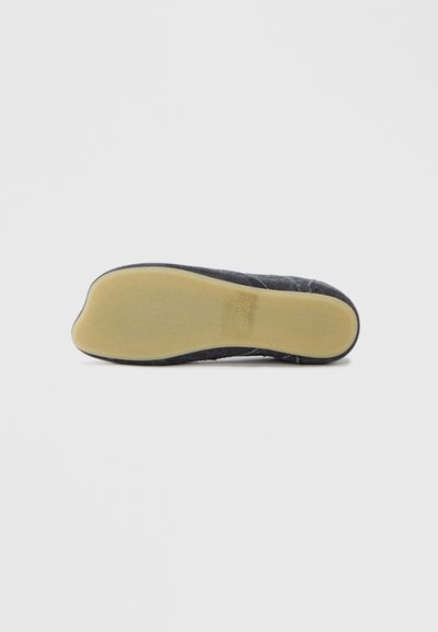 Μαύρη υφασμάτινη σόλα παπουτσιού με λεία βάση από ελαστικό ανοιχτού καφέ χρώματος. Διαθέτει ευέλικτο σχέδιο και στρογγυλεμένη μύτη. Η υφή φαίνεται μαλακή και ανθεκτική.