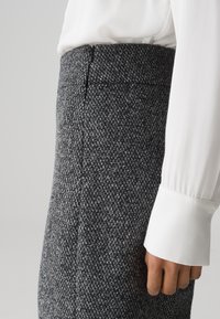 Grijze geruite rok van gestructureerde stof, met een getailleerd silhouet, een gladde tailleband en een verborgen rits aan de achterkant.