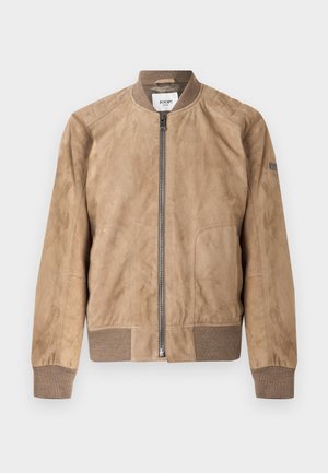Beige sandaalihahkainen bomber-takki, jossa edessä vetoketju, resorikaulus, hihansuut ja helma sekä vähäiset saumaustiedot.
