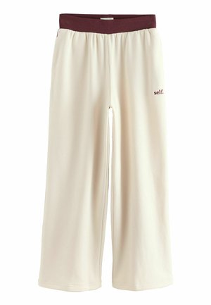 Pantaloni larga de culoare crem cu o talie elastică bordeaux, având un mic logo „self.” în bordeaux pe partea din față.