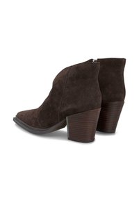 Botas de tobillo de ante marrón oscuro con tacones bloque apilados y cremalleras laterales, ligeramente en ángulo con una bota delante de la otra sobre un fondo blanco.