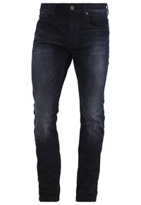 Jeans de mezclilla azul oscuro con corte ajustado, que cuentan con cinco bolsillos, cierre frontal de botón y detalles de costura a lo largo de las costuras.
