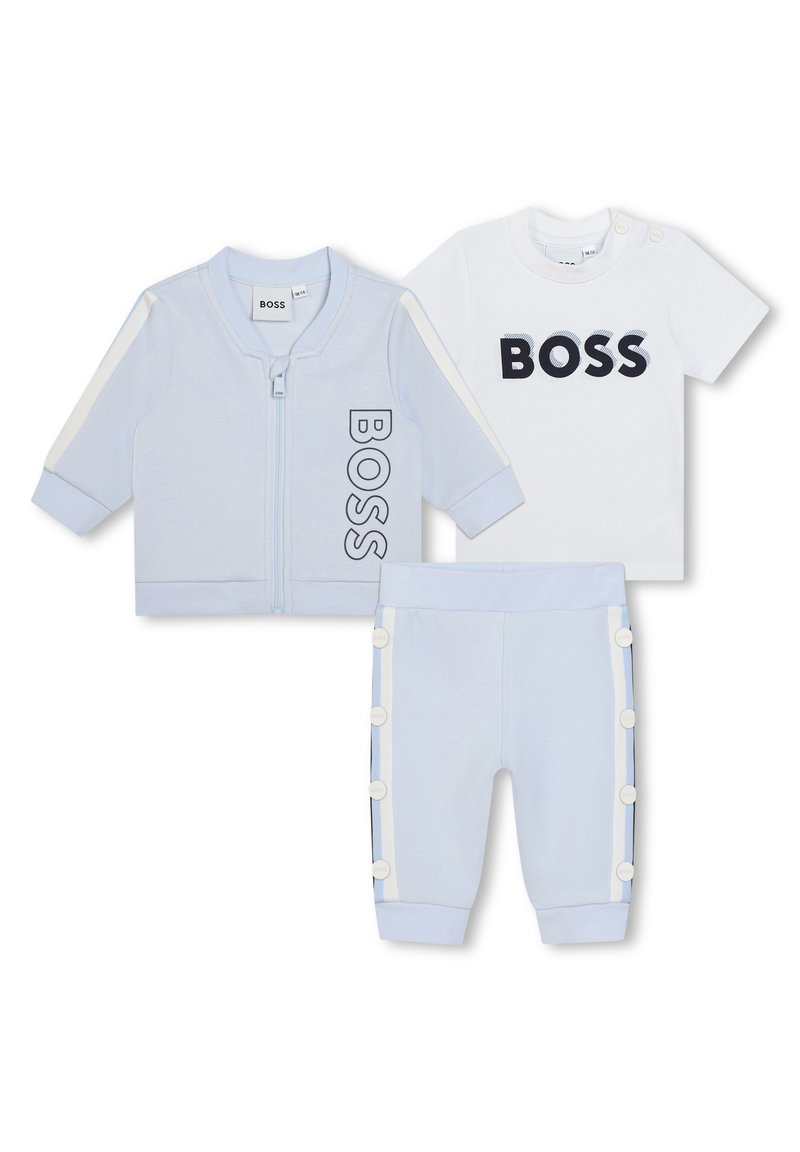 Conjunto de chándal para bebé en algodón azul claro. Incluye chaqueta con cremallera con el logo "BOSS", camiseta blanca con logo y pantalones con detalles de botones.