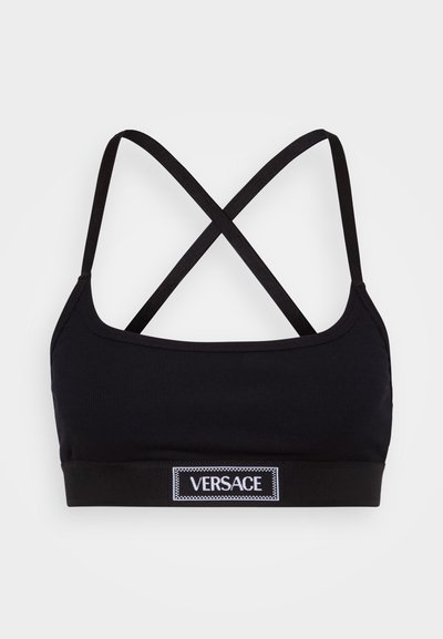 Melna ribota bralette ar krustu aizmugurē. Priekšpusē ir melns pārslēdzams ar baltu "VERSACE" uzlīmi. Vienkāršs dizains.