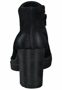 Bottines en cuir noir avec une finition texturée, un talon épais et haut, et une fermeture éclair sur le côté. Le talon présente des détails en relief verticaux.