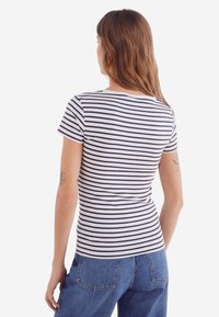 Gestreept T-shirt met korte mouwen in marineblauw en wit, met een geribbelde textuur. Strak ontwerp met een ronde halslijn en minimalistische stijl.