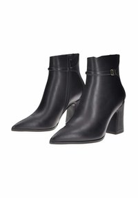 Stivaletti neri in pelle con punta affusolata, tacco a blocco di altezza media e cerniera laterale. Presentano una fascia decorativa con un accento metallico.