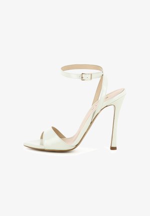 Weiße High-Heel-Sandale mit Knöchelriemen, offenem Zehenbereich und dünnem Stiletto-Absatz vor schlichtem weißem Hintergrund.