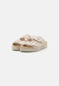 Beige sandaalit, joissa on teksturoitu päällinen, kaksi säädettävää solkea, pehmustetut pohjalliset ja uritettu pohja paremman pidon saavuttamiseksi.