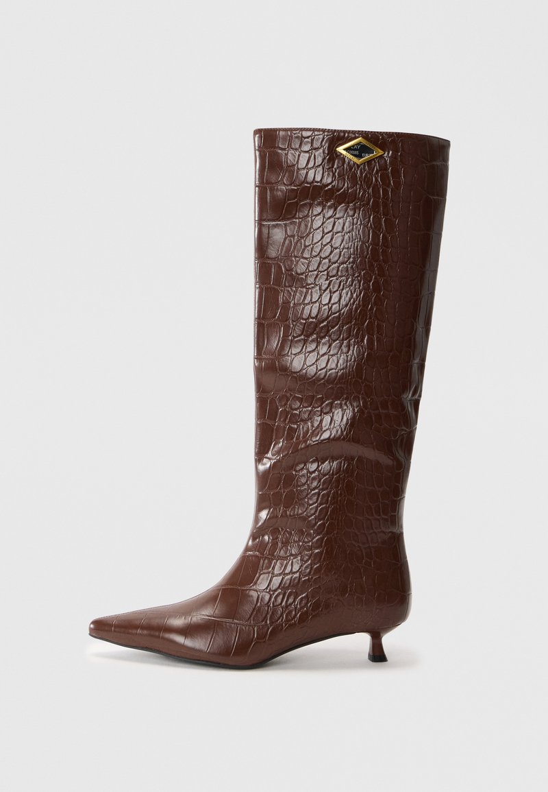 Bottes en cuir marron avec motif crocodile, montantes jusqu'au genou, à bout pointu et petit talon carré. Présente un accent doré en forme de diamant.