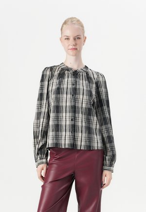 Svart og beige rutet skjorte med rynket hals og lange ermer, kombinert med glinsende burgunder lærbukser.