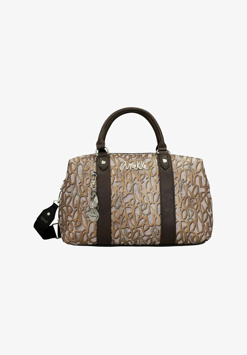 Sac à main marron et crème avec motif en relief, doté de poignées et d'accents marron foncé. Comprend un charme et des détails décoratifs.