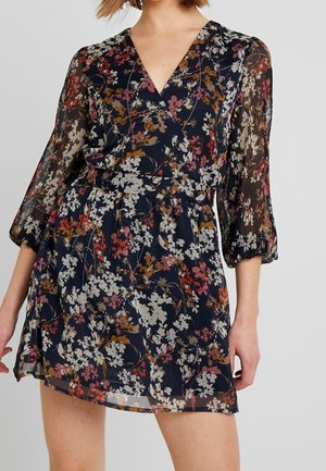 Blumenkleid mit navy Hintergrund, featuring einen V-Ausschnitt, durchsichtige lange Ärmel und einen elastischen Bund, geschmückt mit bunten Blumenmustern.