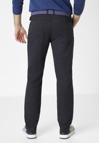 Black, straight-leg pants with a smooth texture, featuring two back pockets and a contrasting patterned blue belt. Worn with gray sneakers.