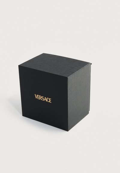 Μαύρο πολυτελές κουτί με υφή και χρυσό λογότυπο "VERSACE" στο κέντρο, σε λευκό φόντο.