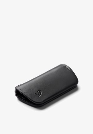 Schwarzes Lederportemonnaie mit glatter Textur, abgerundeten Kanten und einem auf der Vorderseite eingeprägten Logo. Das Design verfügt über einen Überschlagverschluss.