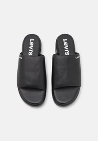 Sandales à glissière noires en cuir avec une texture lisse. Dotées d'une large sangle et d'un logo imprimé sur la semelle. Design simple, ouvert à l'avant.