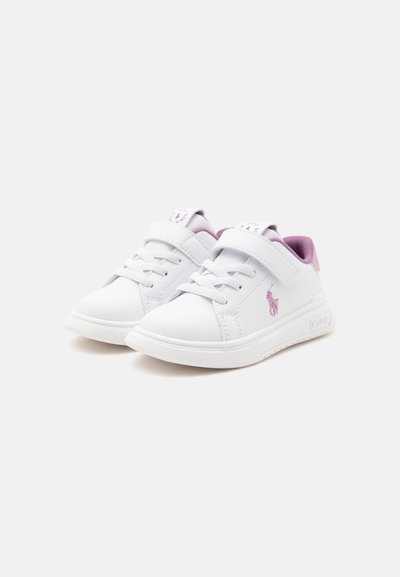 Ζευγάρι λευκά παιδικά αθλητικά παπούτσια με ροζ εσωτερικό, μωβ λογότυπο, κορδόνια και αυτοκόλλητα βέλκρο σε λευκό φόντο.