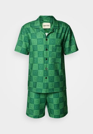 Zelena kratka majica s kratkimi rokavi in kratke hlače z vzorcem mreže ter cvetličnimi poudarki in črnimi gumbi. Lahkoten material.