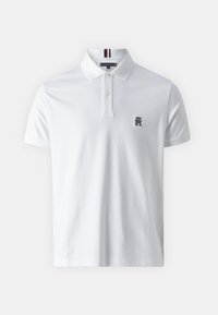 Polo bianco realizzato in cotone, con una patta a due bottoni, maniche corte e un piccolo logo ricamato sul lato sinistro del petto.