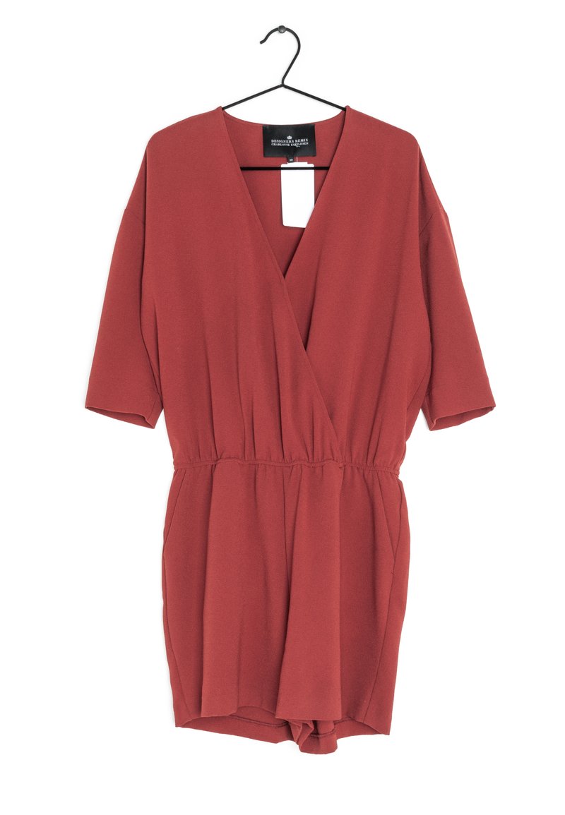 Robe de couleur rouille avec des manches courtes, décolleté en V, taille élastique et jambes courtes. Fabriquée dans un tissu lisse, avec une étiquette attachée.