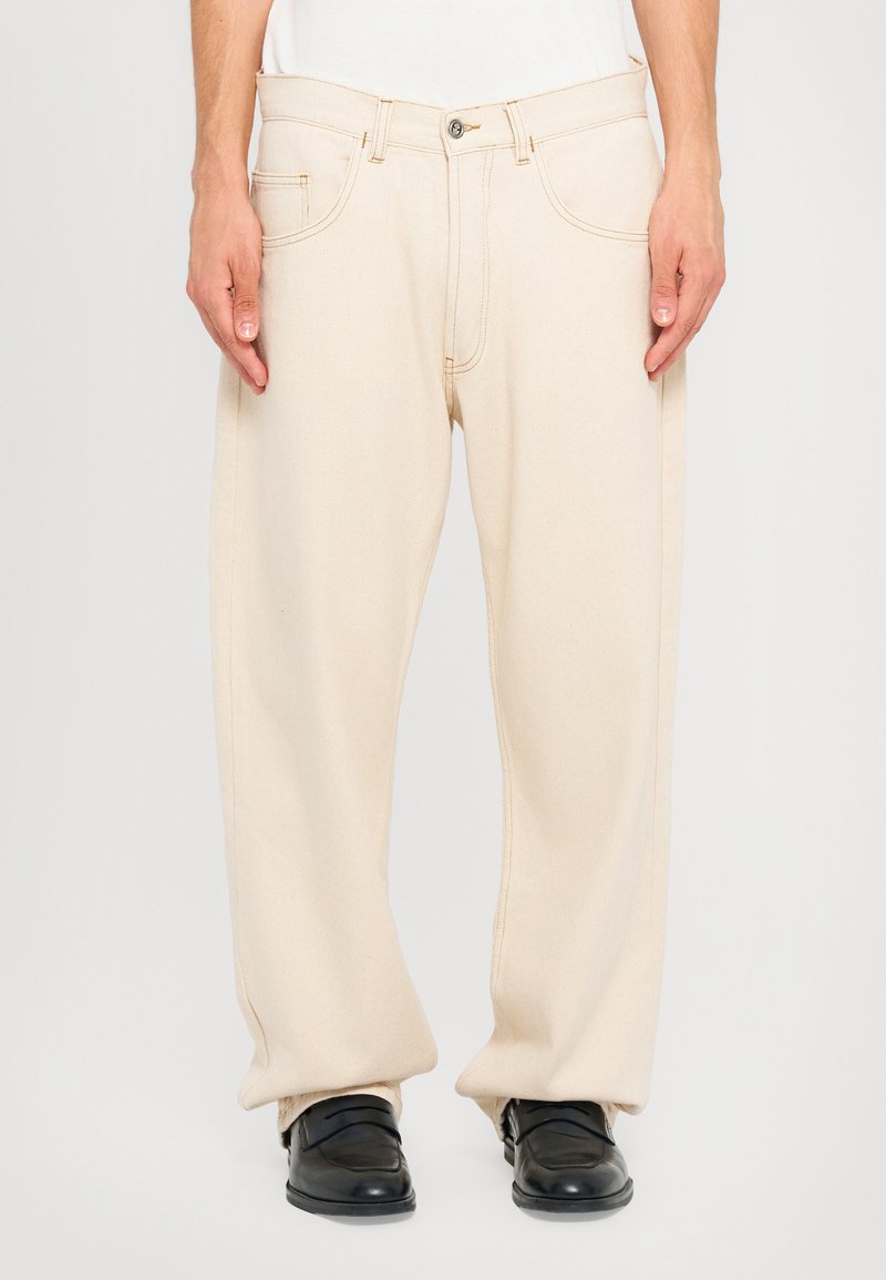 Pantaloni in cotone beige con design a gamba dritta, dotati di chiusura con bottone e tasche laterali. Struttura liscia, dettagli di cucitura minimi.