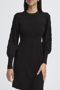 Abito nero in maglia con corpetto a coste e maniche a sbuffo strutturate. Presenta una vita aderente e un orlo liscio, che mette in risalto un tessuto accogliente.