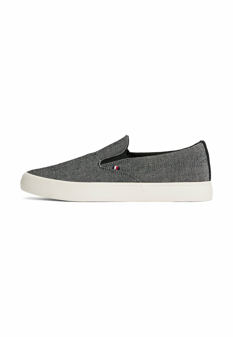 Scarpe slip-on in tessuto grigio con finitura testurizzata, suola in gomma bianca e dettagli elastici ai lati. Presenta un piccolo logo sul lato.