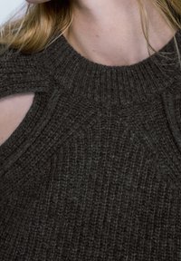 Ciemnoszary dzianinowy sweter z wysokim dekoltem i wycięciami na ramionach. Faktura prążkowana i gruba.