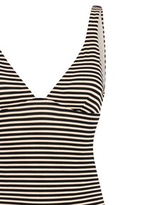 Musta-valkoinen vaakaraidallinen hihaton toppi, jossa on V-aukko ja paksut olkaimet valkoista taustaa vasten.