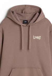 Felpa marrone in cotone con cappuccio regolabile, dotata di tasca a marsupio e logo Vans ricamato in crema sul petto. Tessuto liscio.