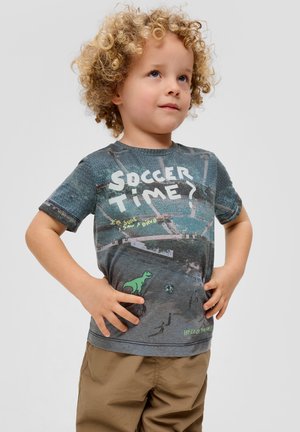 Graues T-Shirt mit kurzen Ärmeln, das ein Grafikmotiv mit einem Fußballfeld, einer Dinosaurier-Illustration und dem Text "Soccer Time?" in fetten weißen Buchstaben zeigt.
