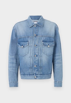 Light blue denim jacket with two chest pockets, silver metal buttons, and a classic collar. Features a faded texture and tailored fit.